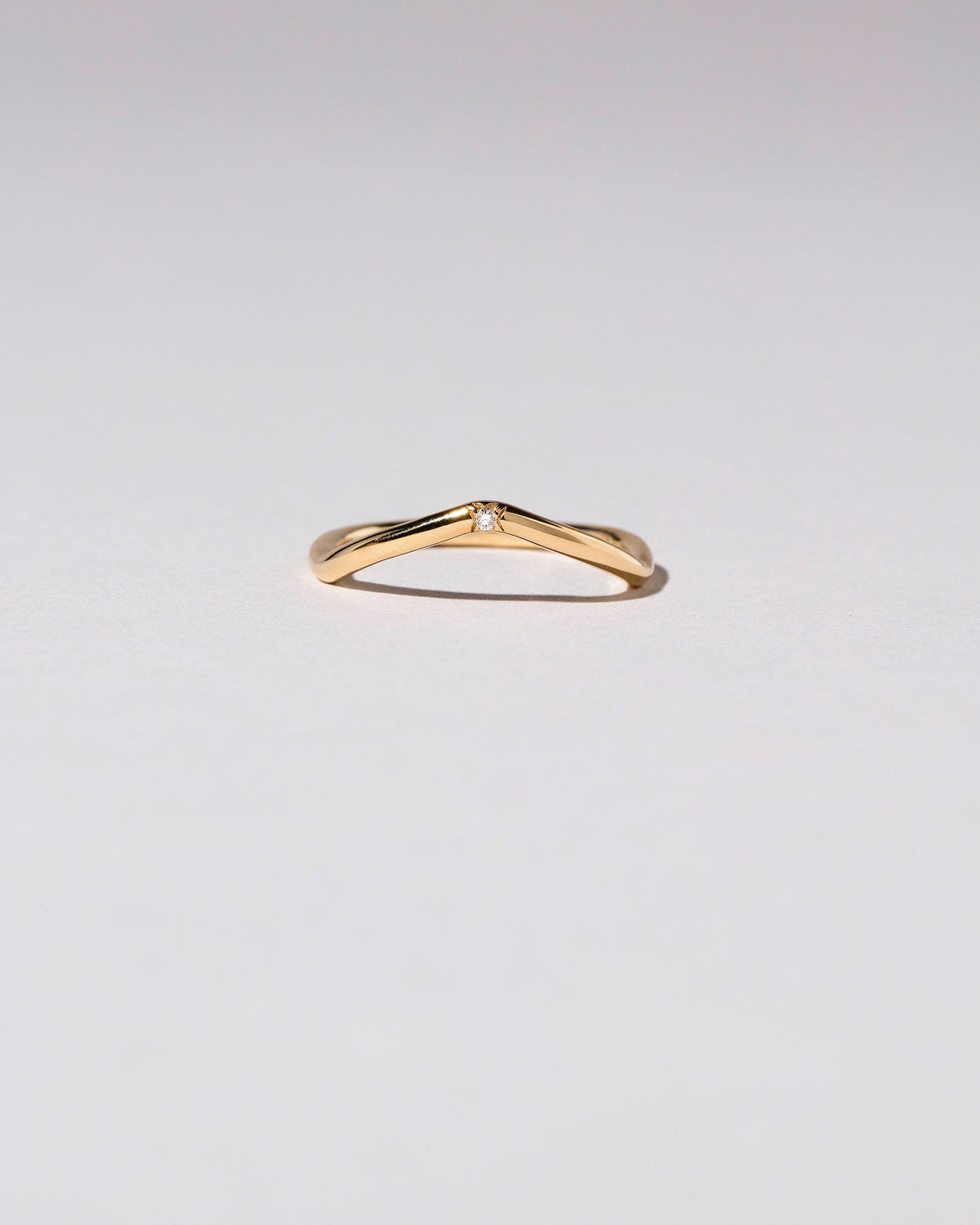 Gold Single Stone White Diamond Low Peak Band on light color background.