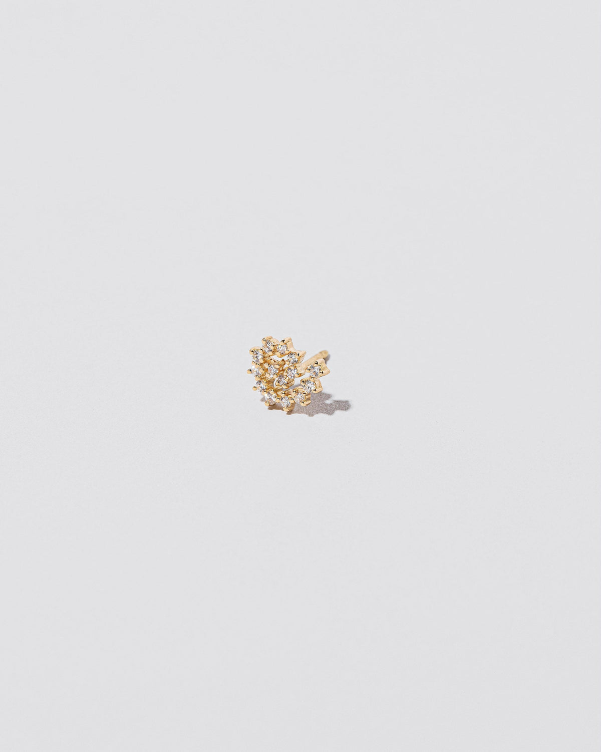 Mini White Diamond Left Spiral Stud Earring Single on light color background.