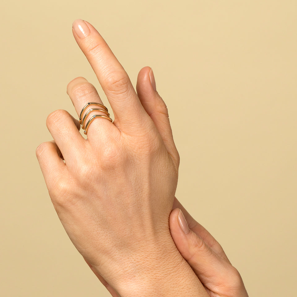 product_details::Gold Three Stone Low Peak Bands on model.