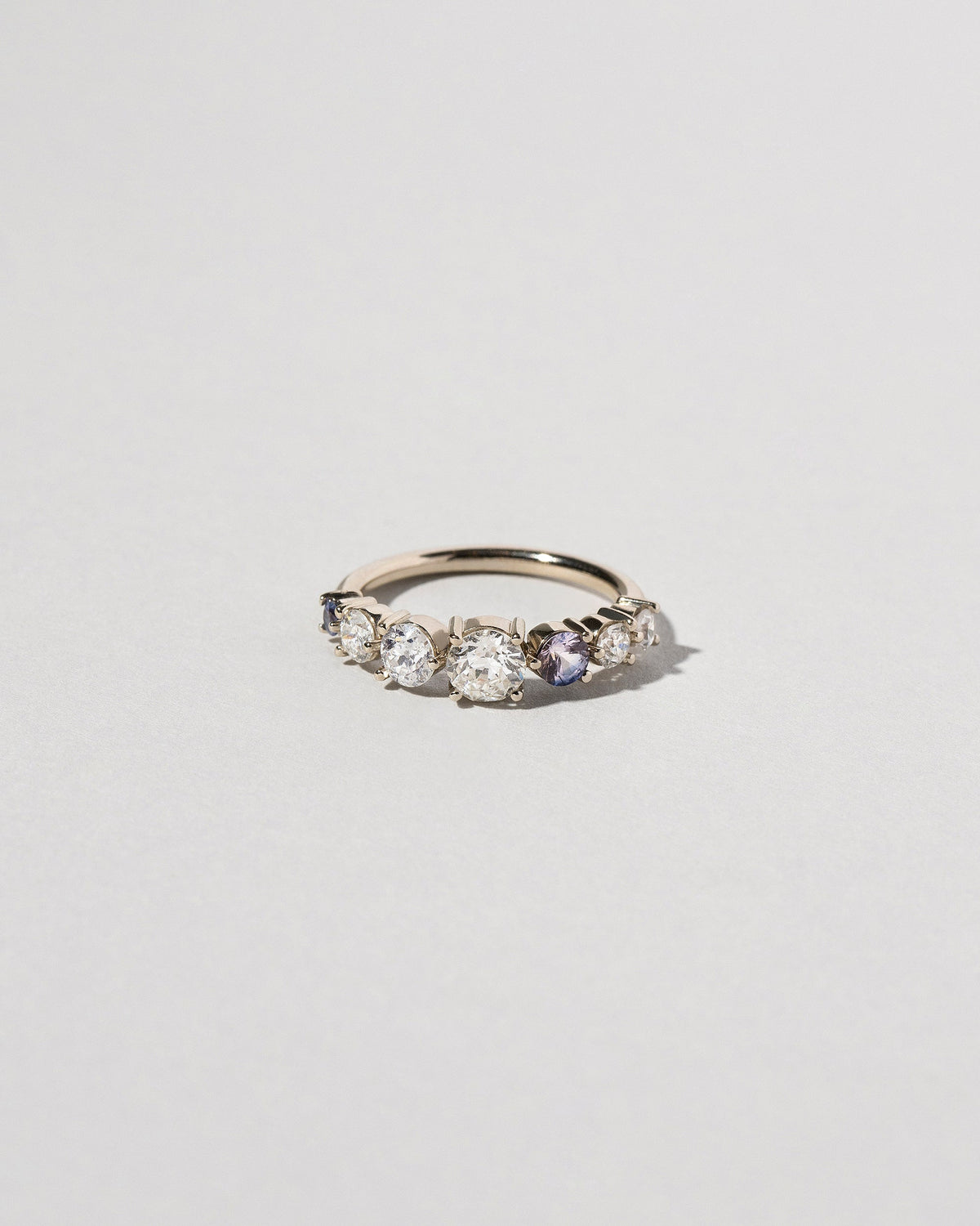 Diamond & Sapphire Line Cluster Ring on light color background.