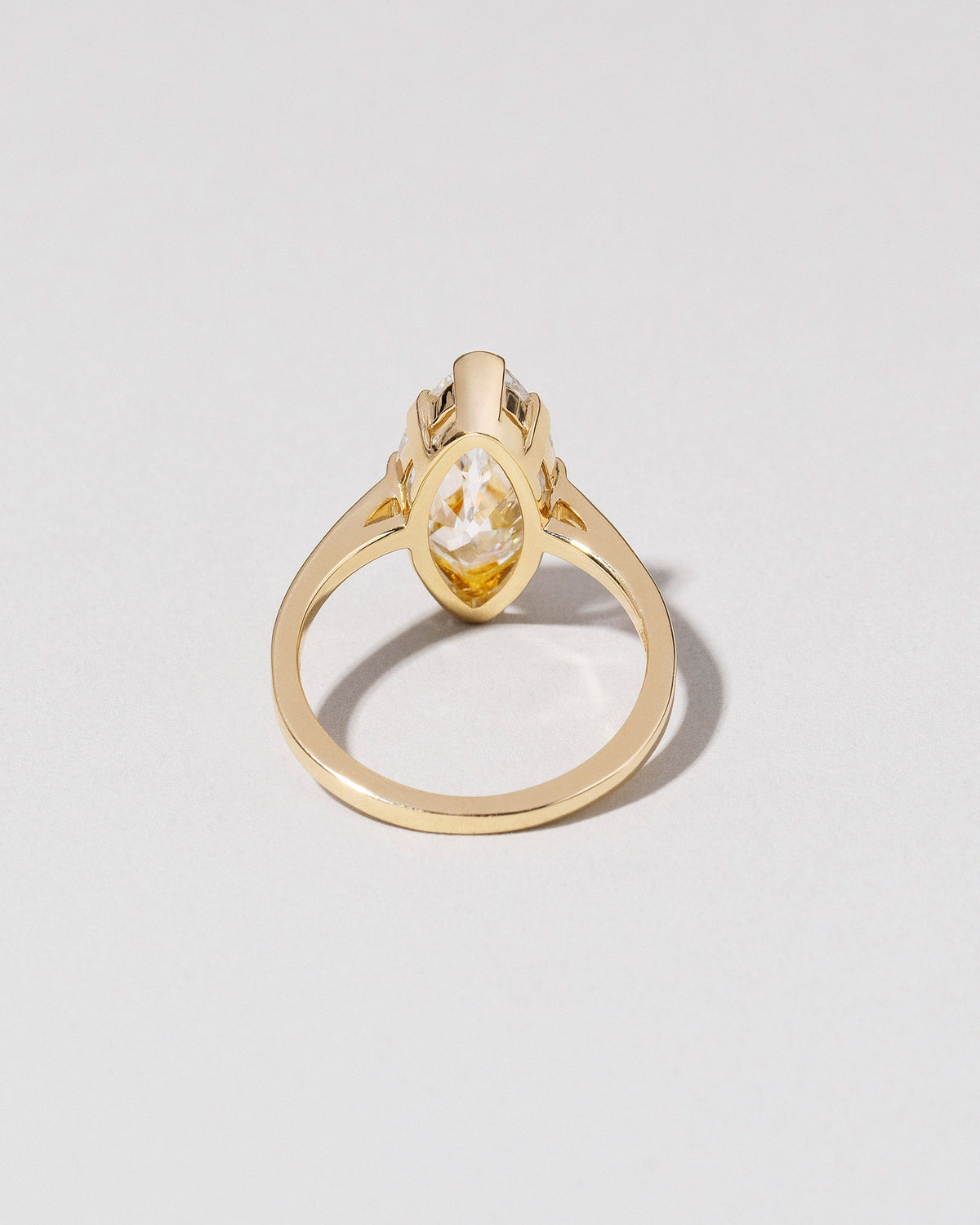 View from the back of the North-South Navette Diamond Solitaire Ring on light color background.