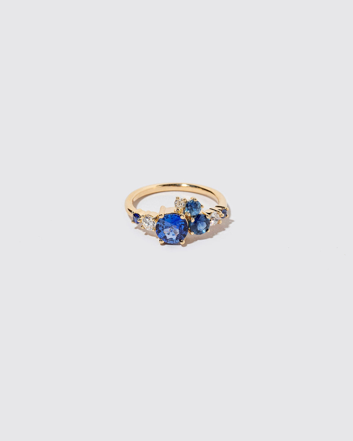 Limited-edition blue sapphire and white diamond Luna Ring on light color background.
