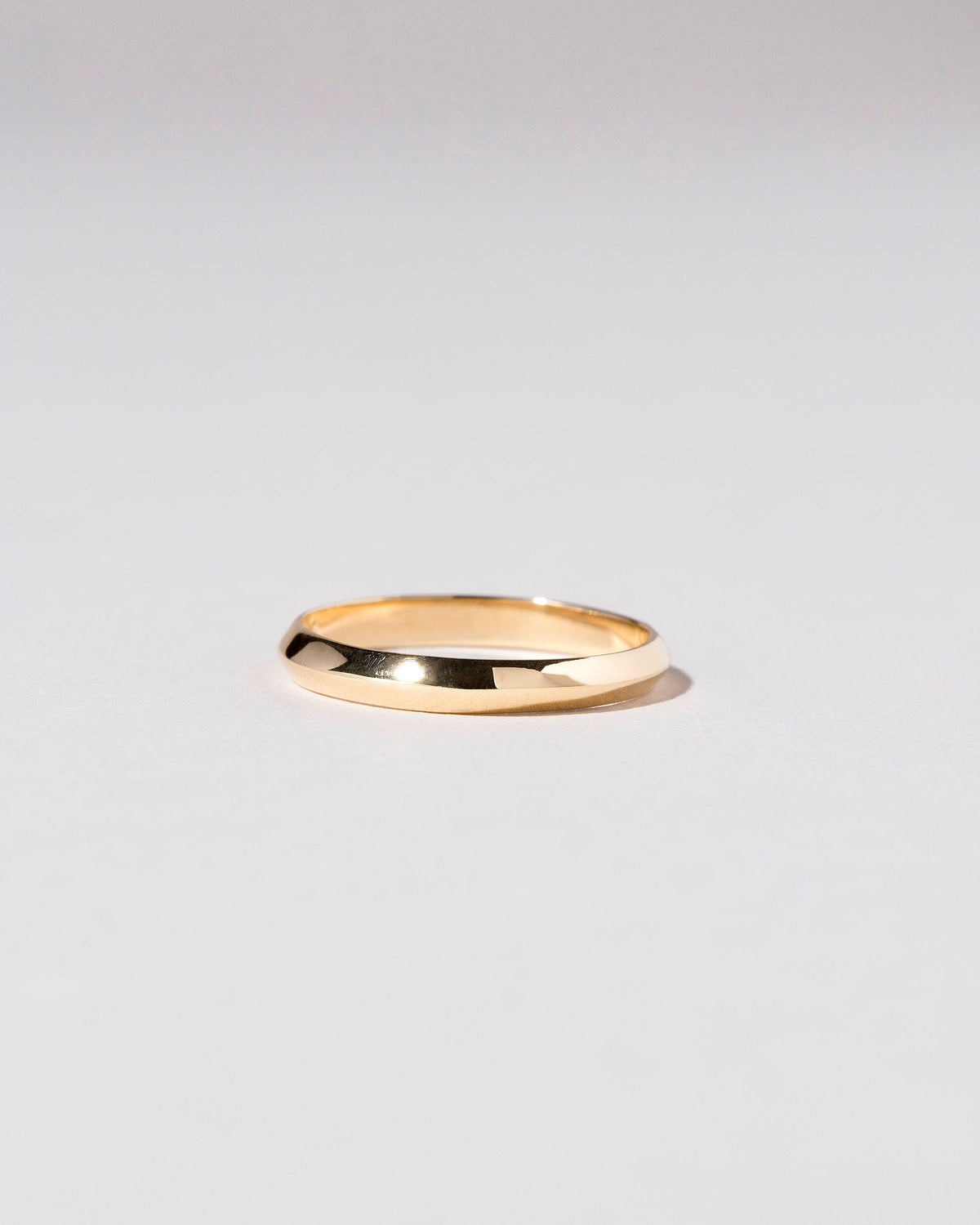 Gold 3mm Knife Edge Band on light color background.