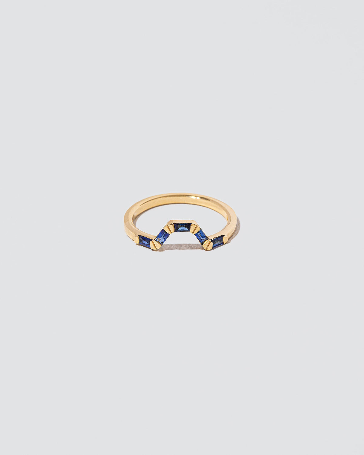 Sapphire Baguette Bridge Band on light color background.