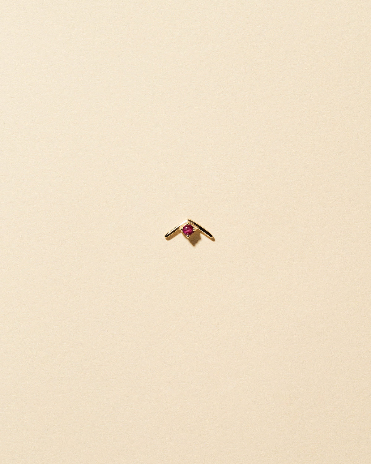 Gold Ruby Sun Catcher Stud Earring Single on light color background.