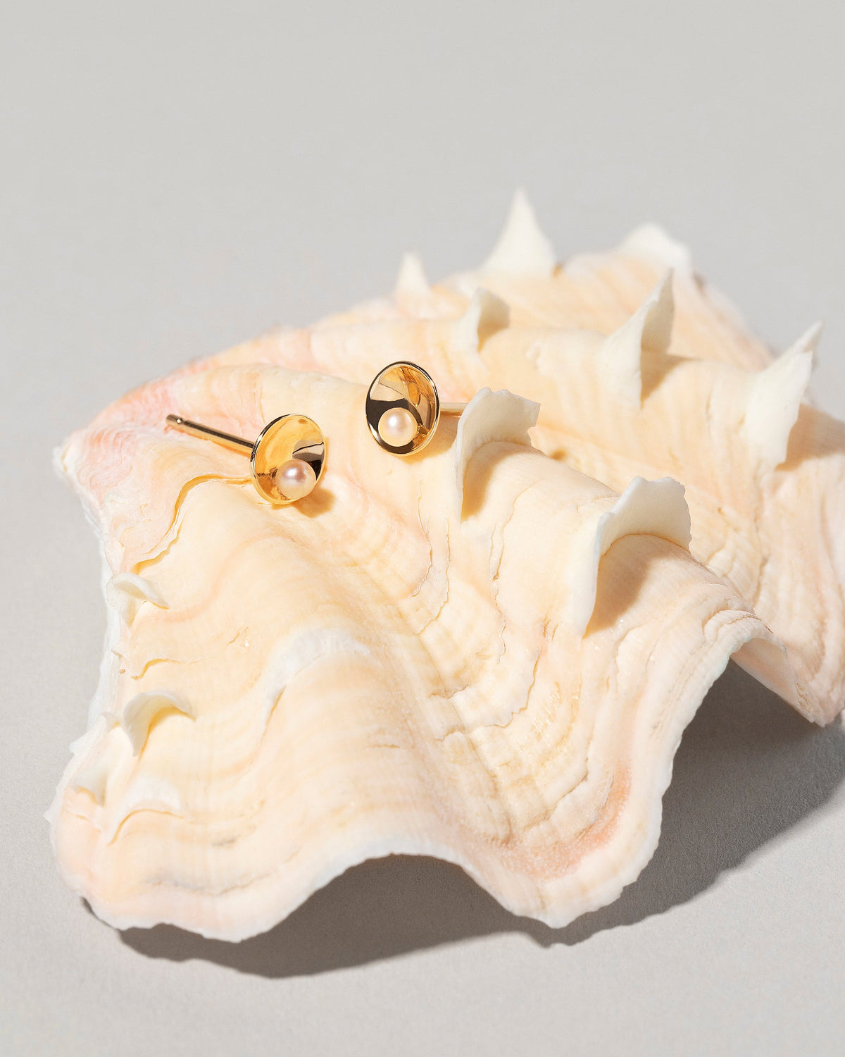 Pearl Cup Earrings on light color background.