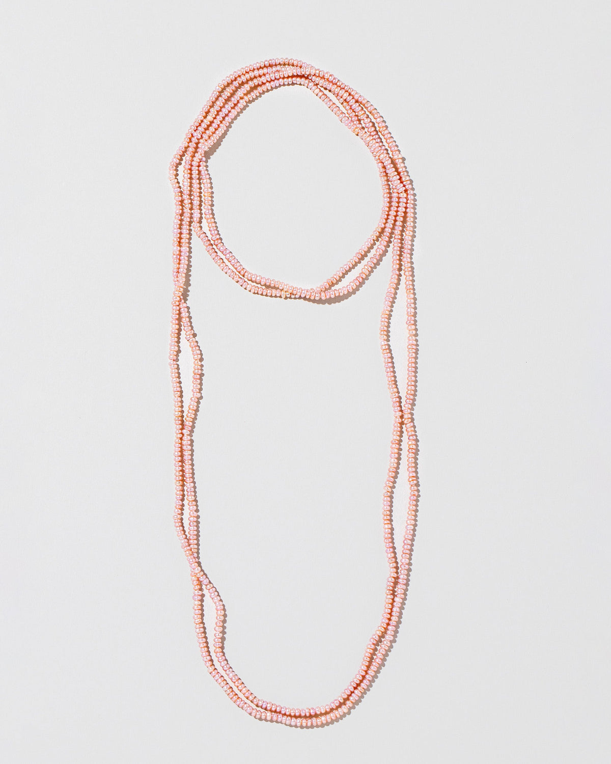 Pink Lavender Seed Pearl Rope Necklace on light color background.