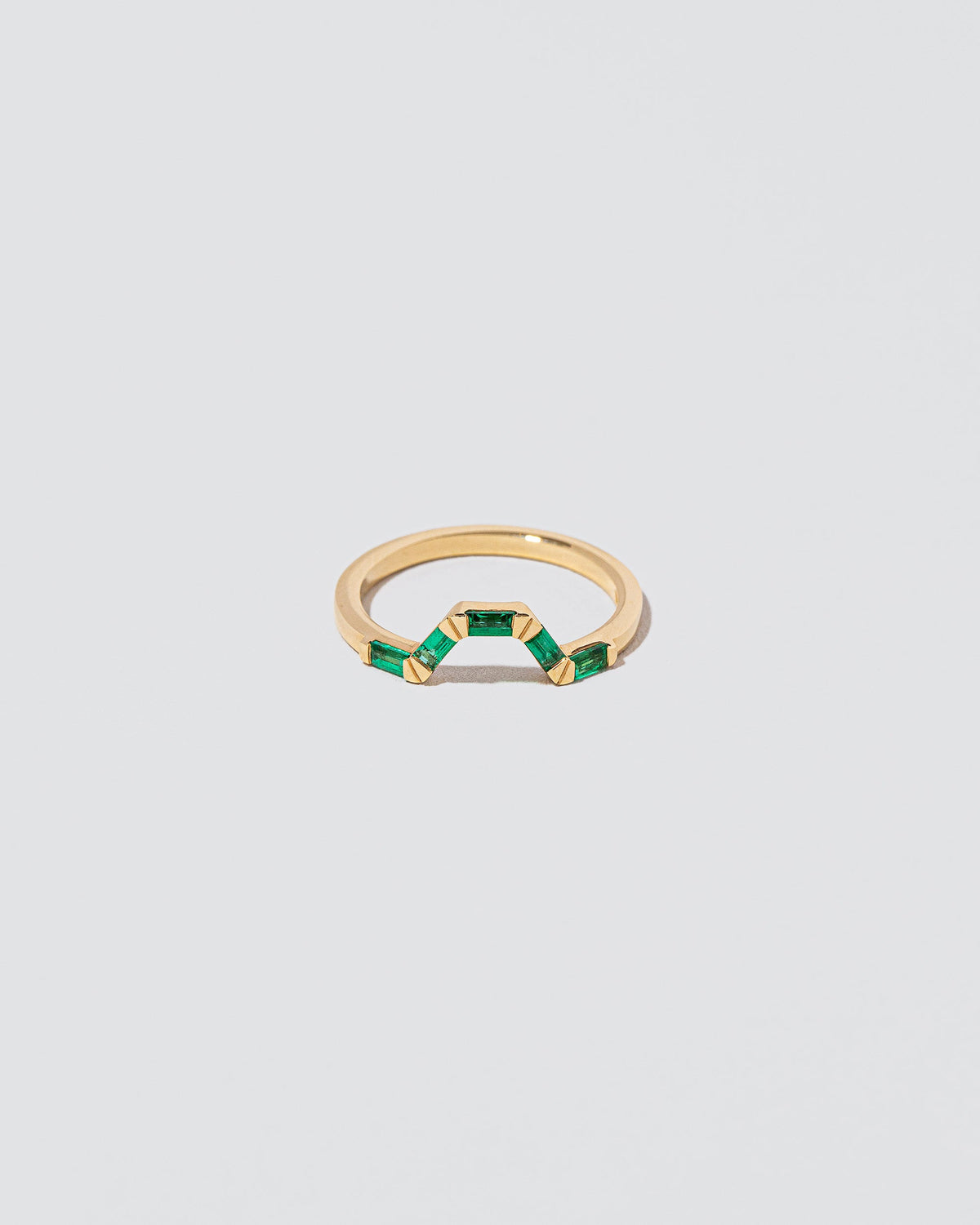 Emerald Baguette Bridge Band on light color background.
