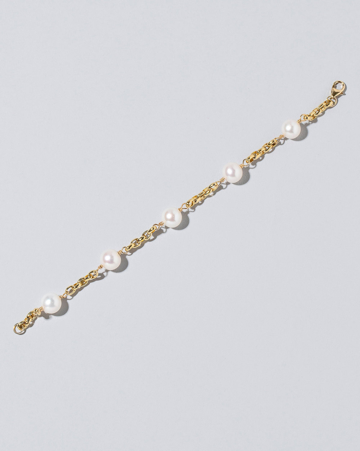 Five Pearl Station Bracelet Short Loop Chain on lightcolor background.