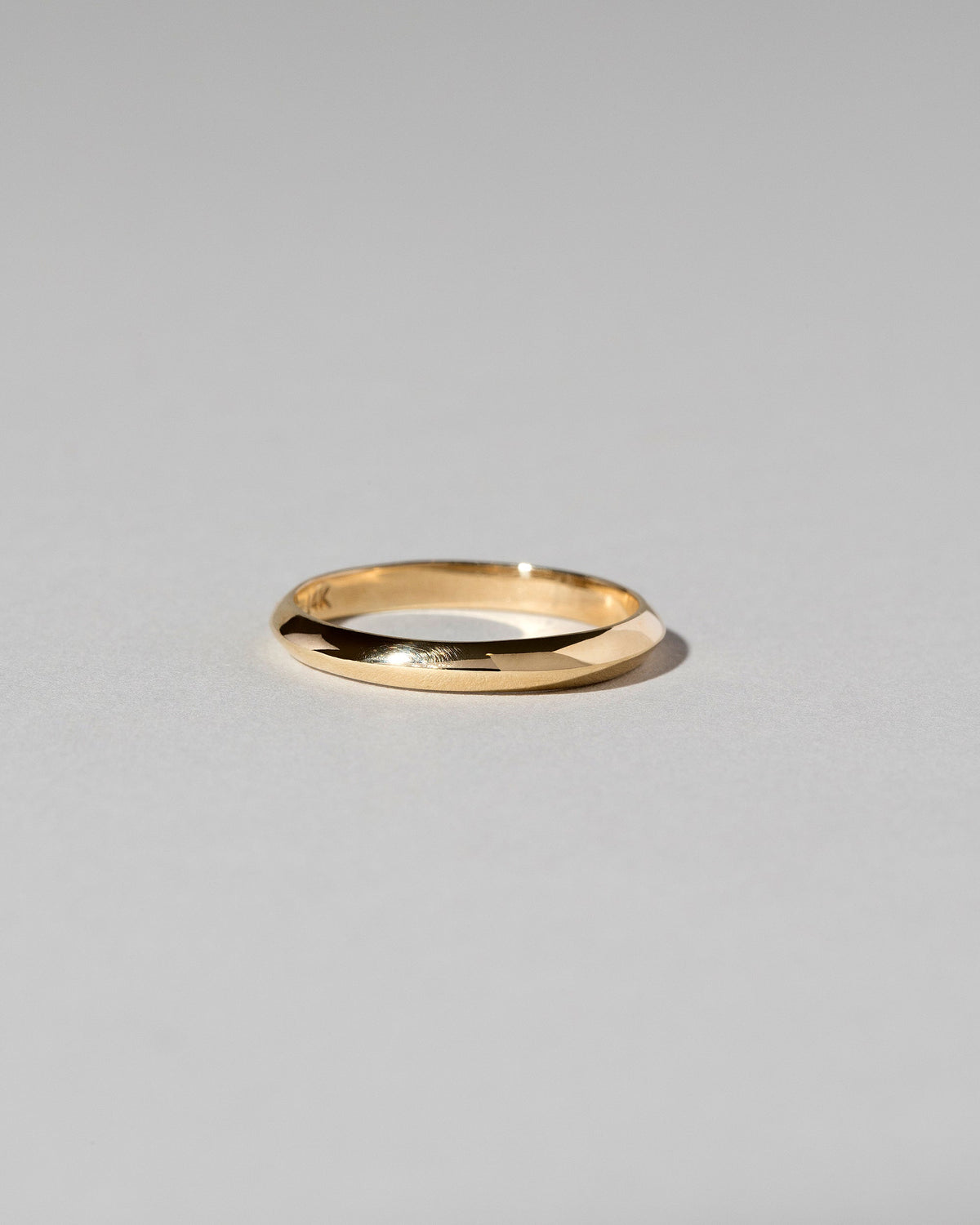 Gold 2mm Knife Edge Band on light color background.