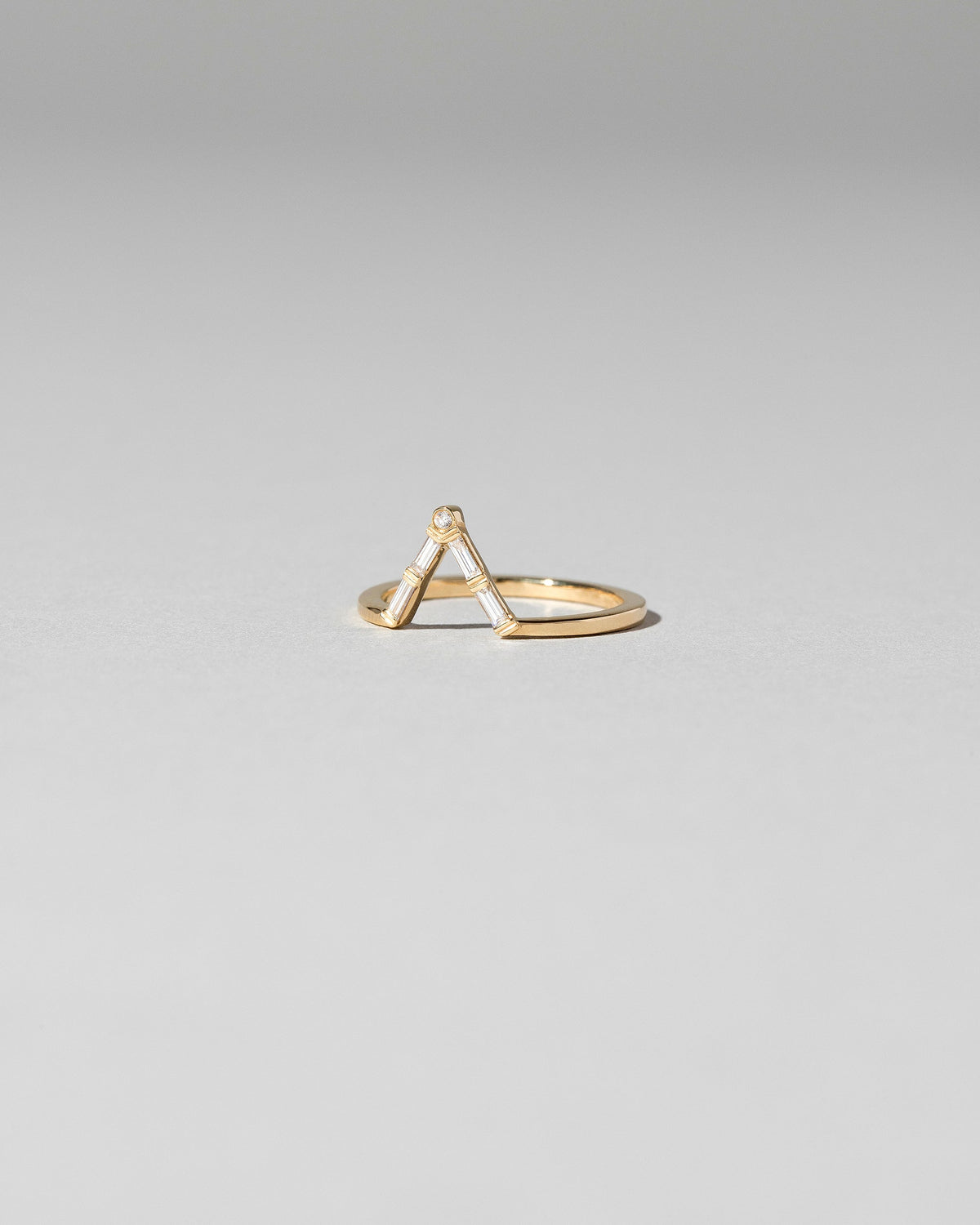 View from the side of the Gold Baguette Triangle Band on light color background.