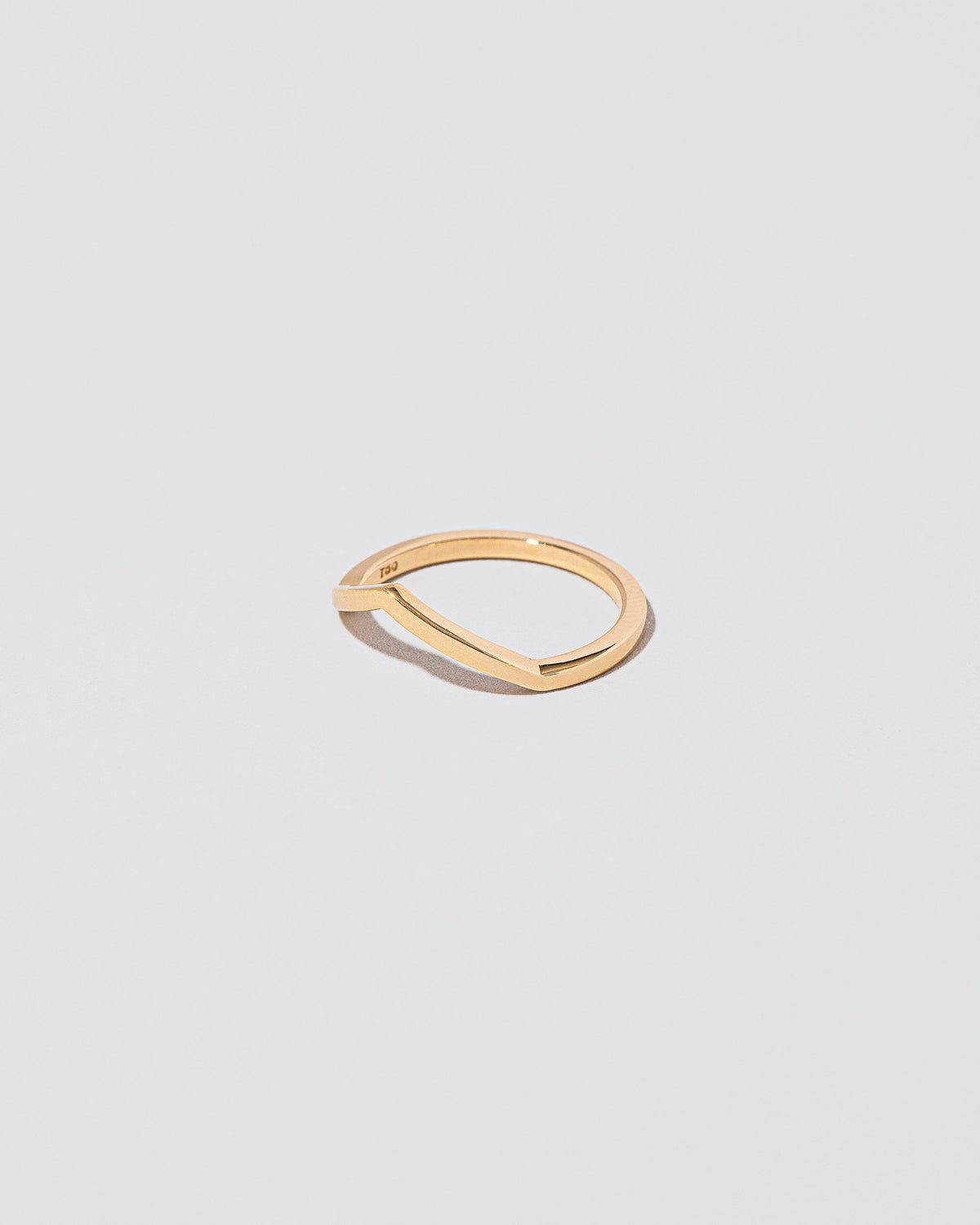 View from the side of the Gold Solid Square Wire Low Peak Band on light colored background.