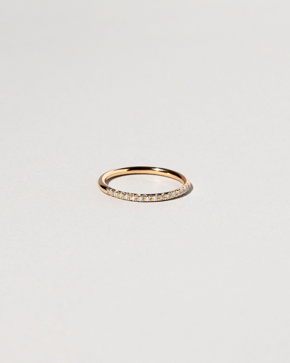 Gold White Diamond Sapphire Fifteen Stone Dot Band on light color background.