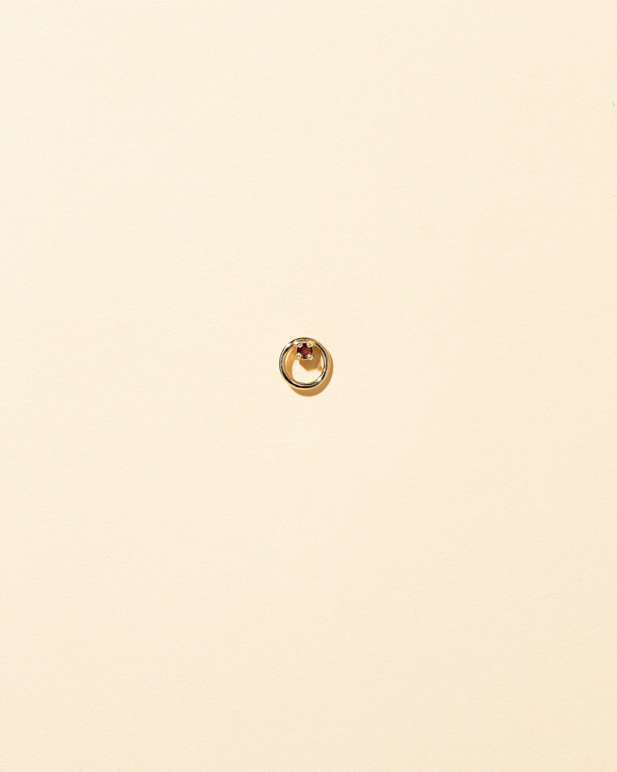 Gold Garnet Full Moon Stud Earring Single on light color background.