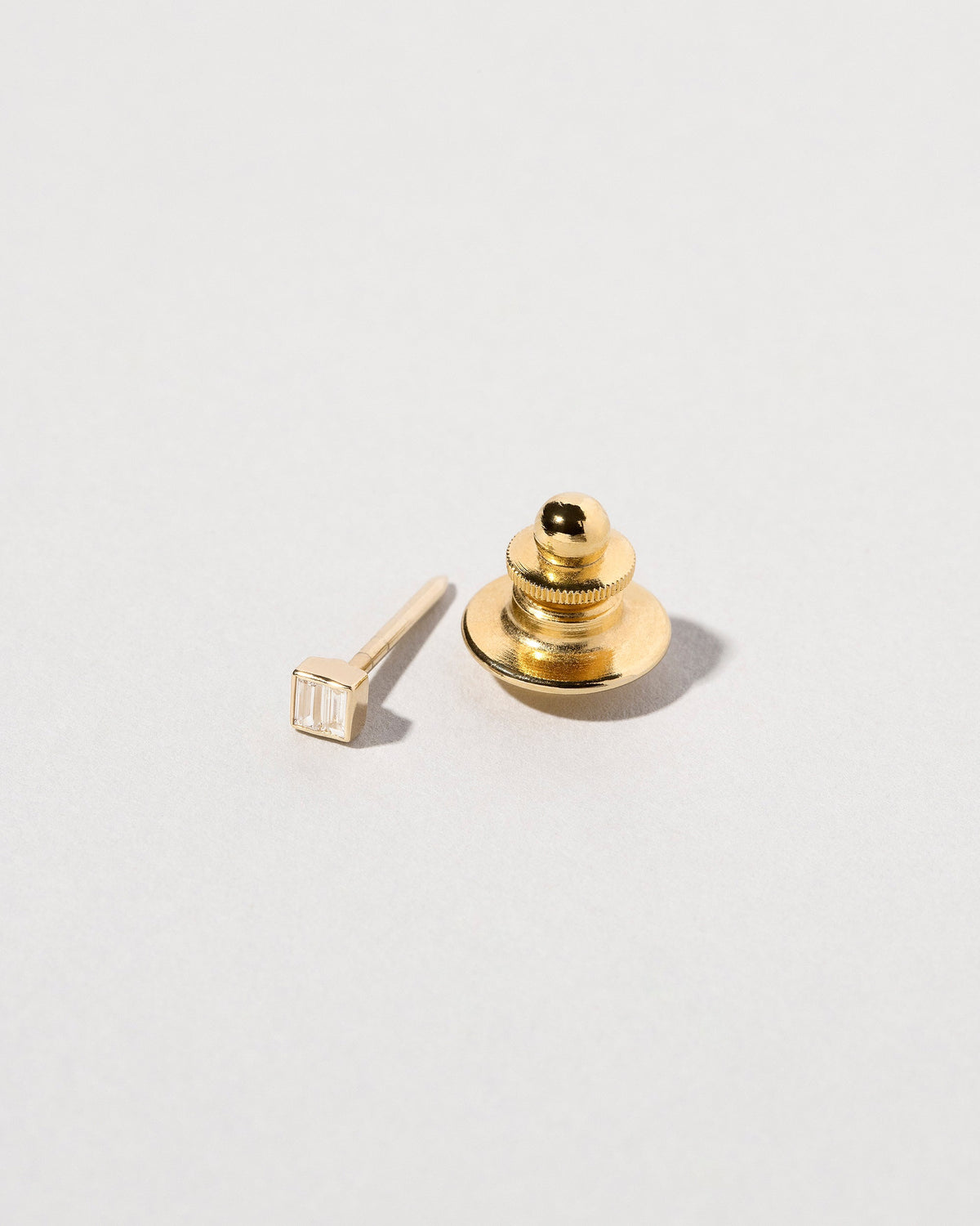 Closeup view of the Diamond Square Collar Pin on light color background.