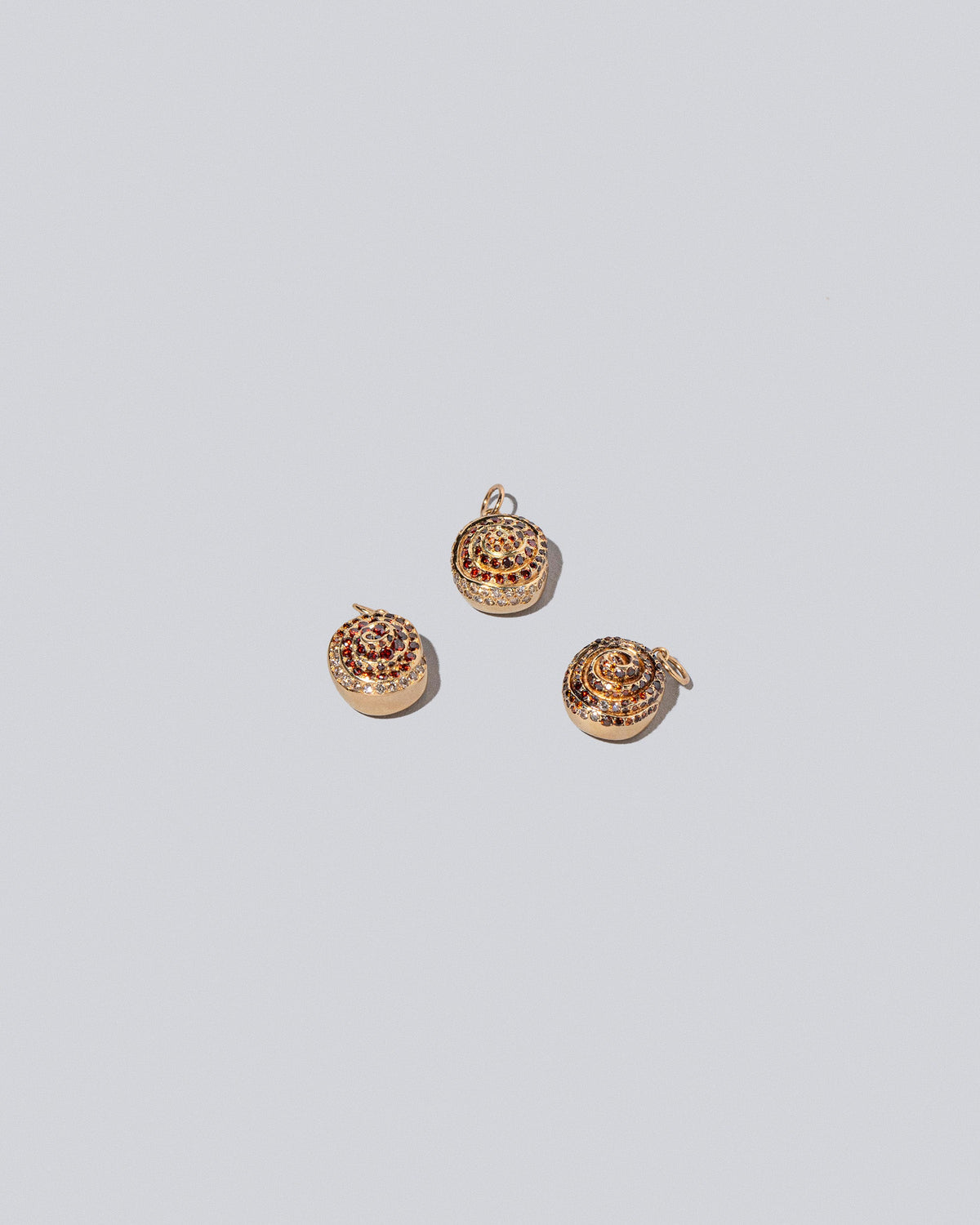 Cinnamon Roll Charm - Pavés on light color background.
