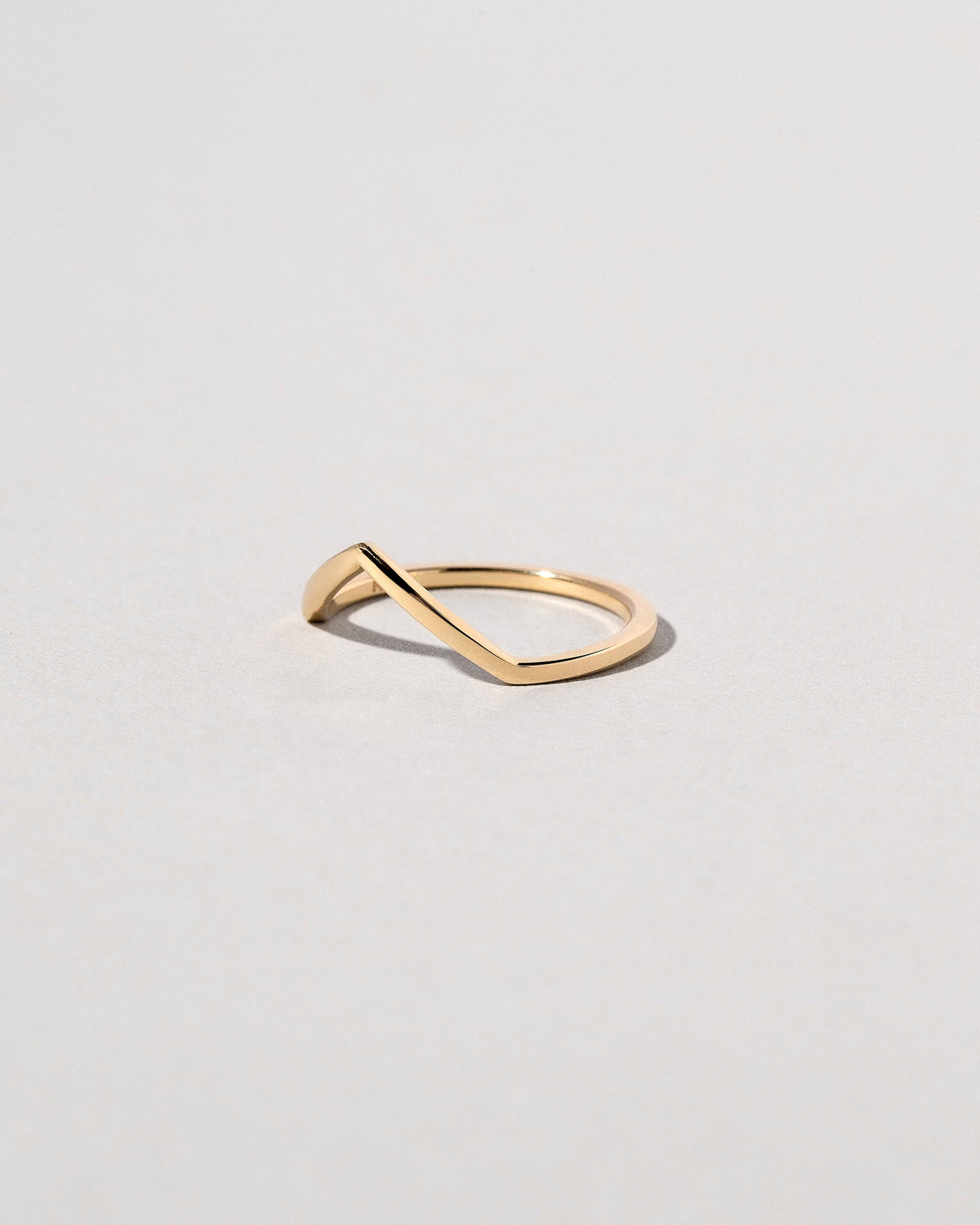 View from the side of the Gold Solid Square Wire High Peak Band on light color background.
