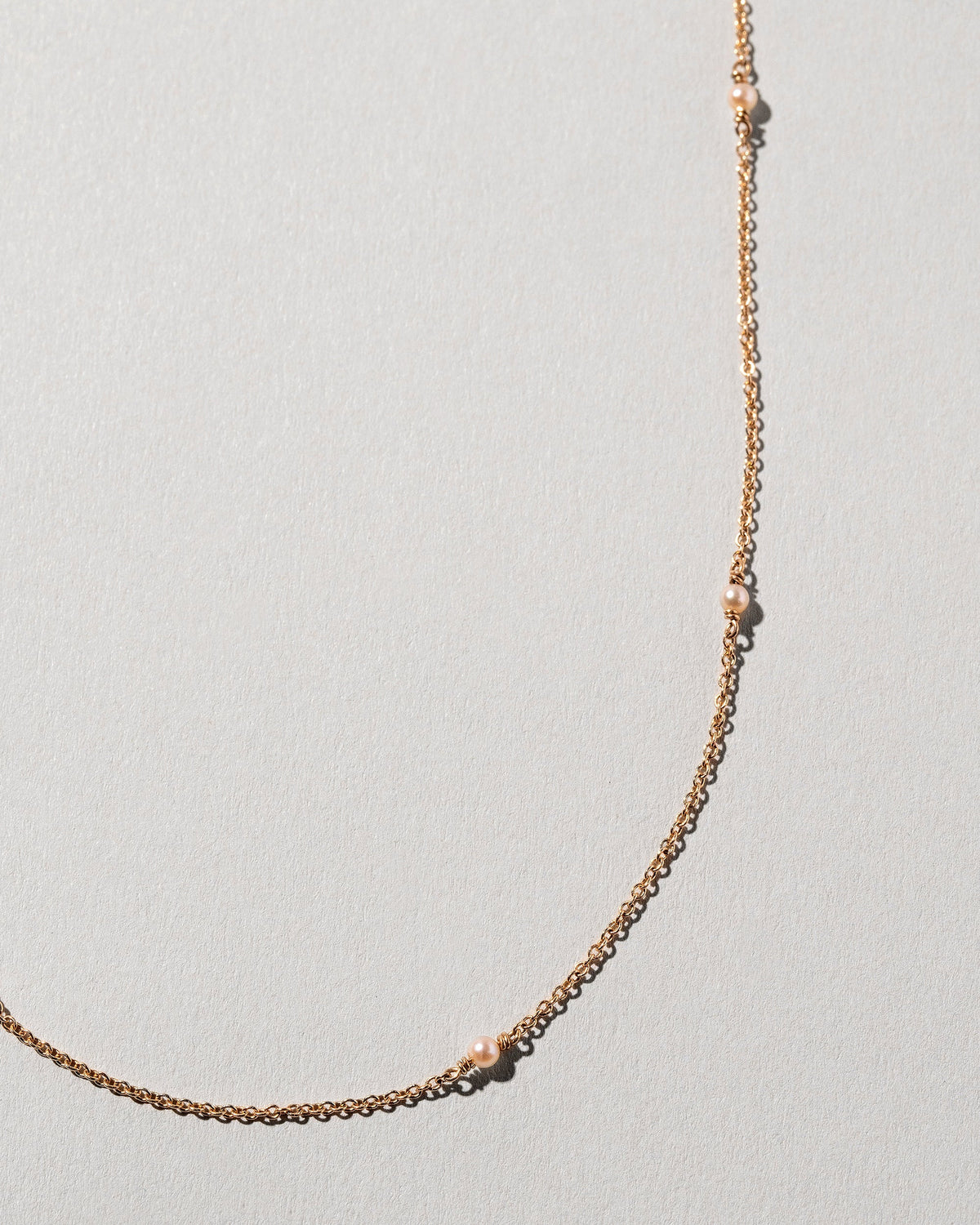  Natural Pink Seed Pearl Necklace on light color background.
