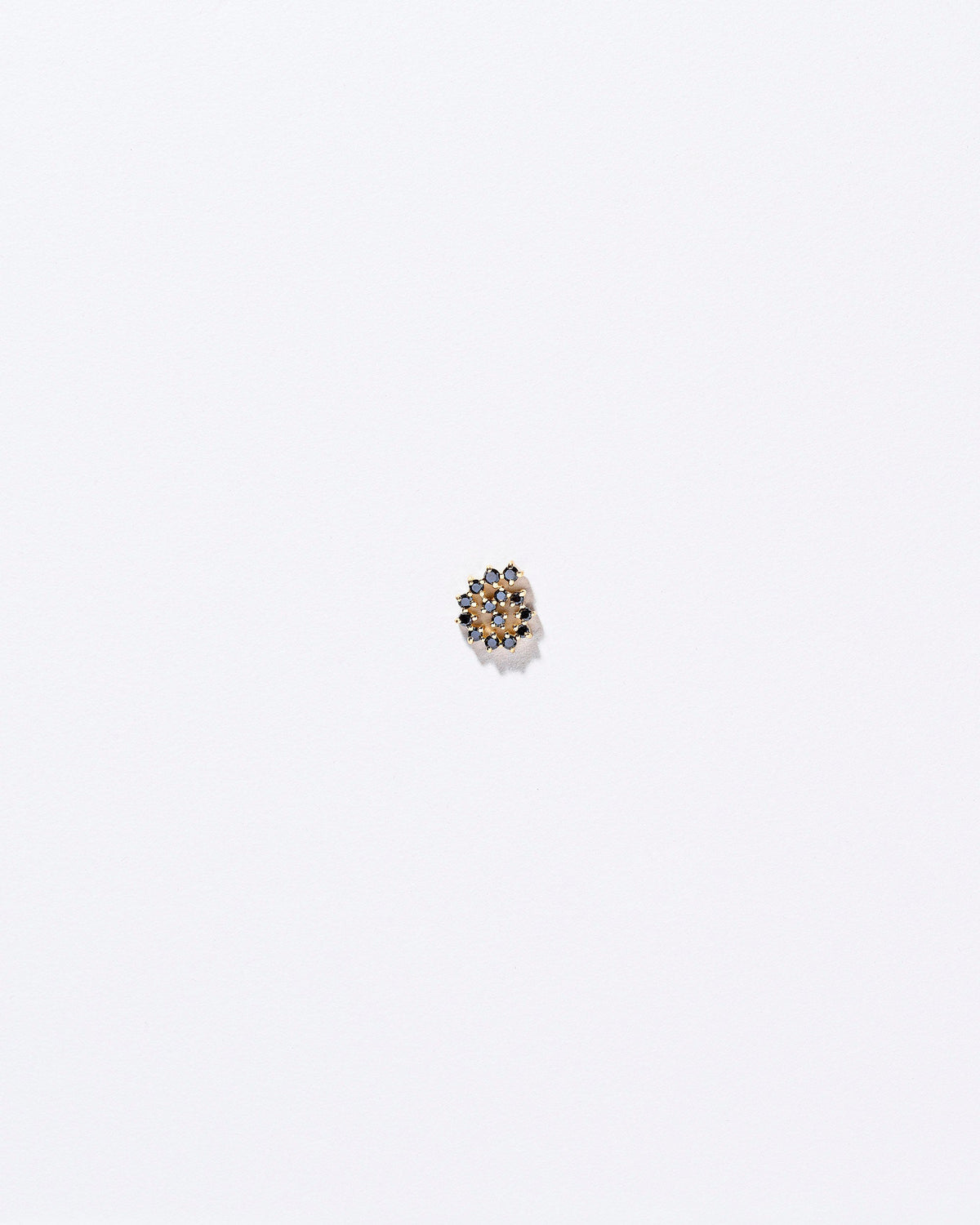 Right Black Diamond Left Spiral Stud Earring Single on light color background.
