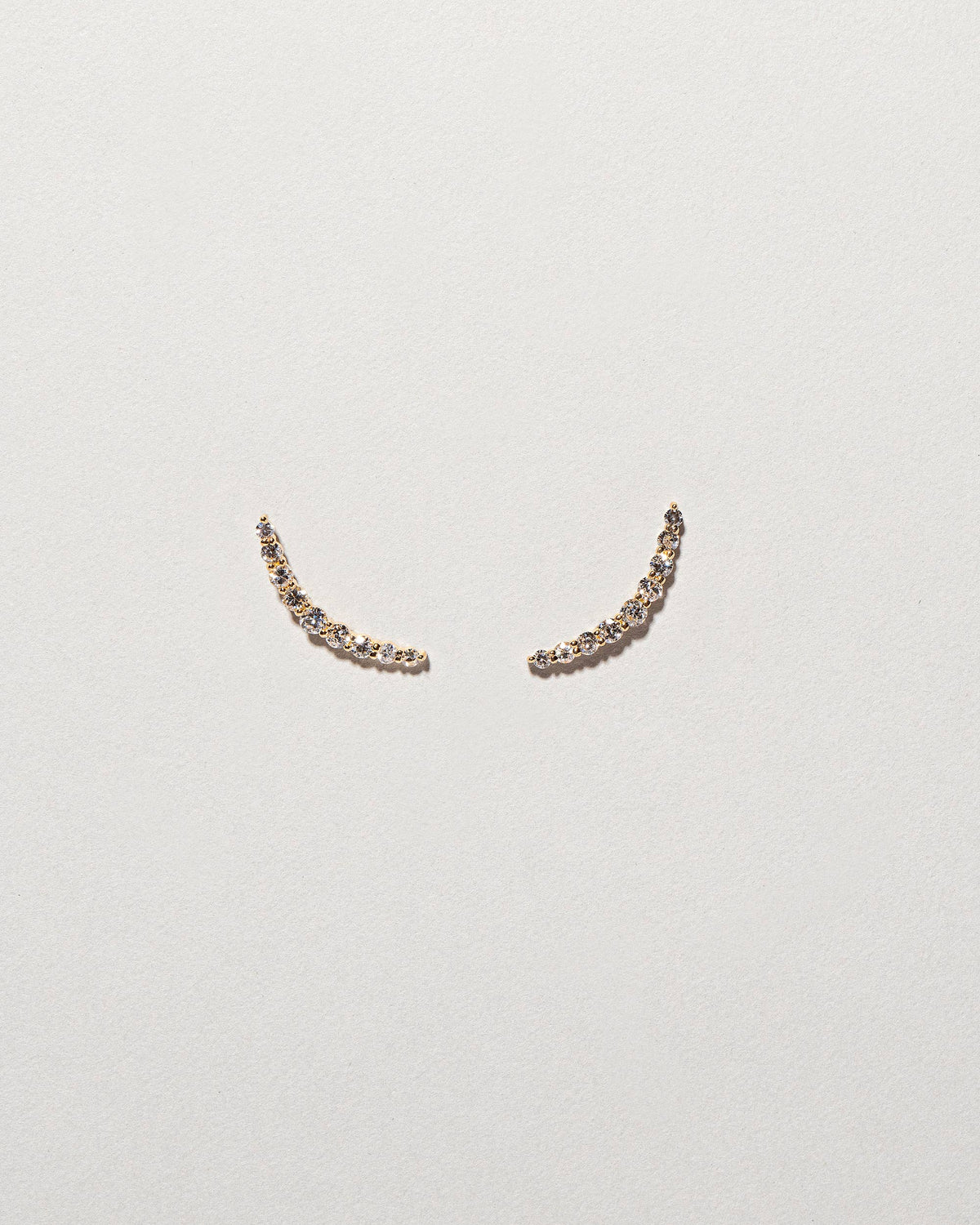  Crescent Ear Climber Studs on light color background.
