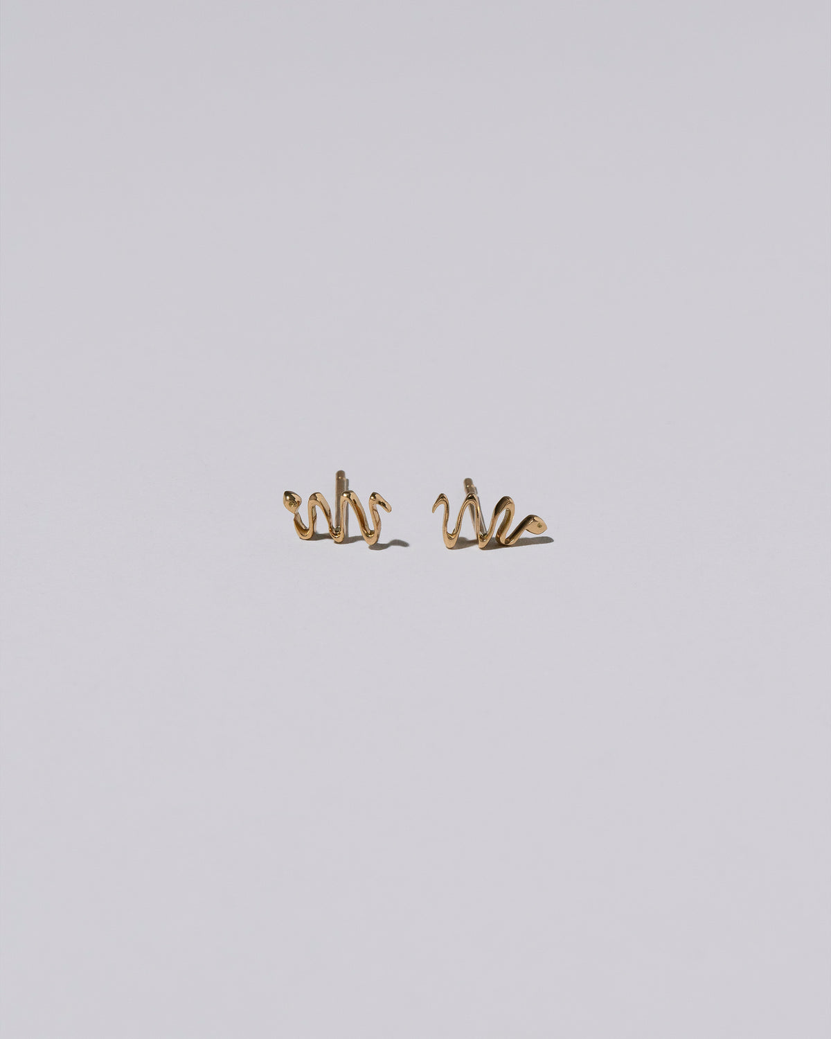Right Snake Stud Earring Single and Left Snake Stud Earring Single on light color background.