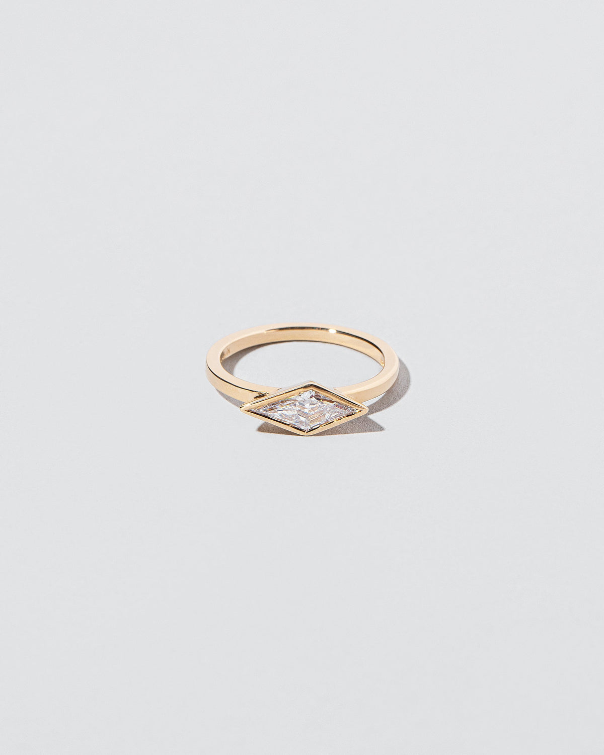 Atomism Ring on light color background.