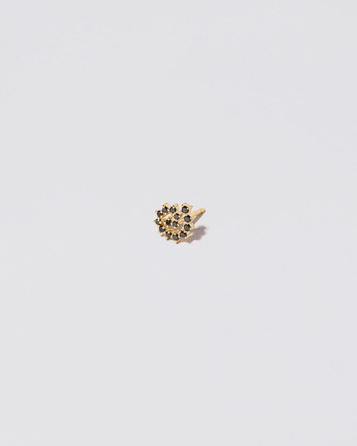 Mini Black Diamond Left Spiral Stud Earring Single on light color background.