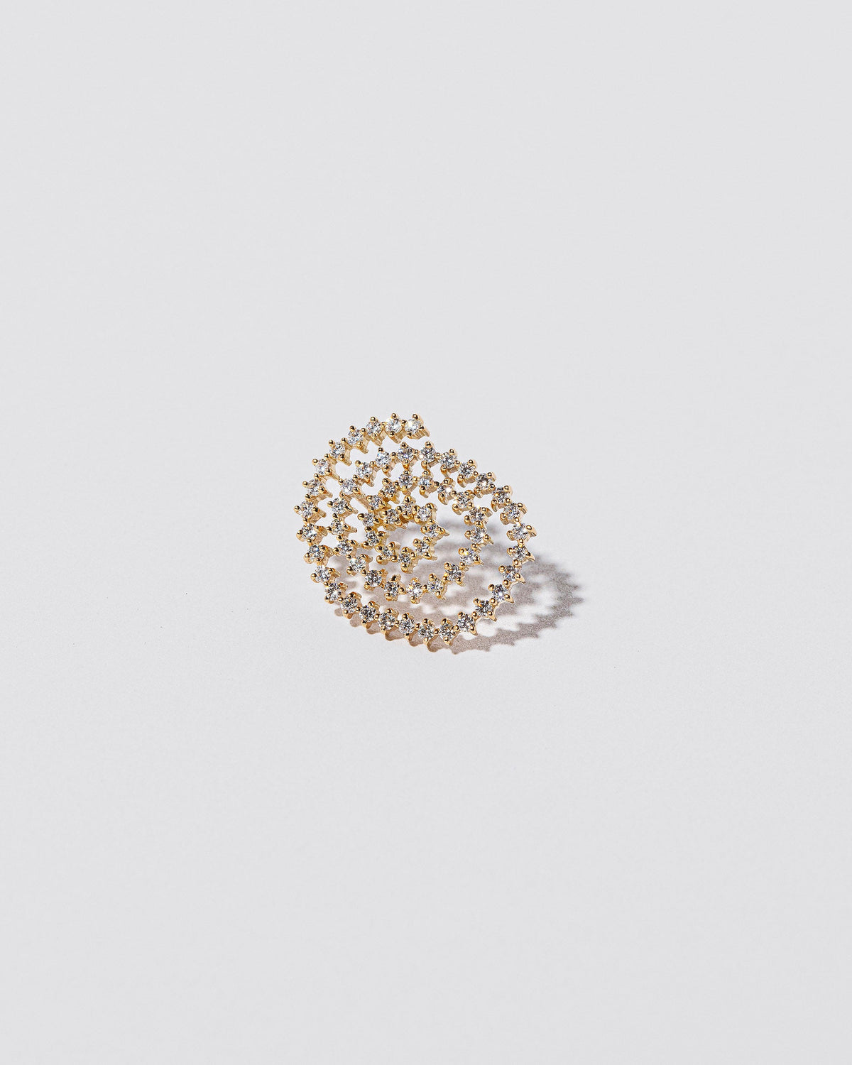 Closeup details of the Right White Diamond Cycle of Rebirth Earring Single on light color background.