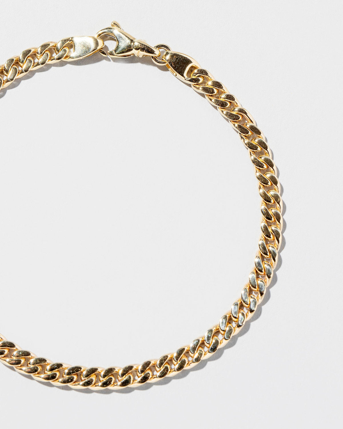 Closeup details of the 4.7mm Curb Chain Bracelet on light color background.