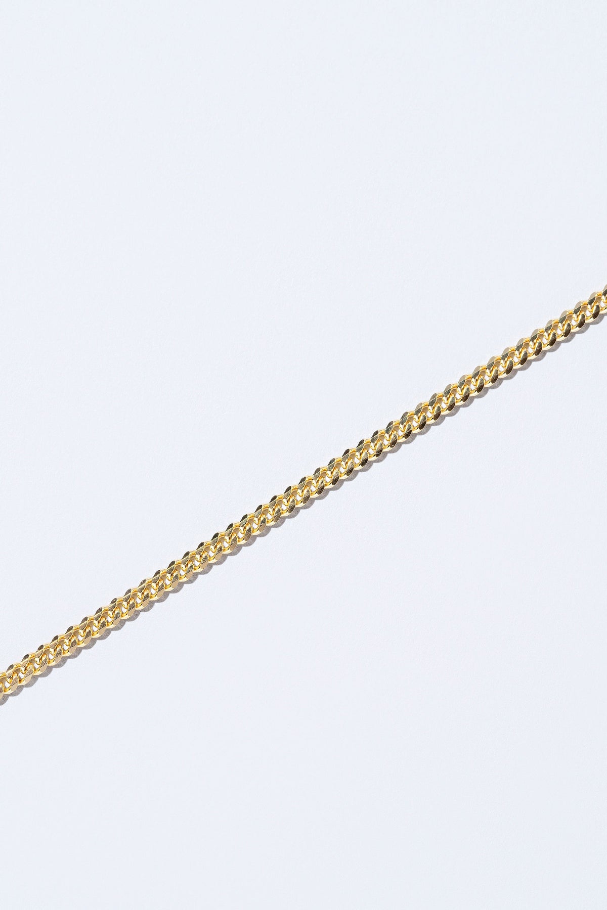 Closeup details of the 3.4mm Curb Chain Necklace on light color background.