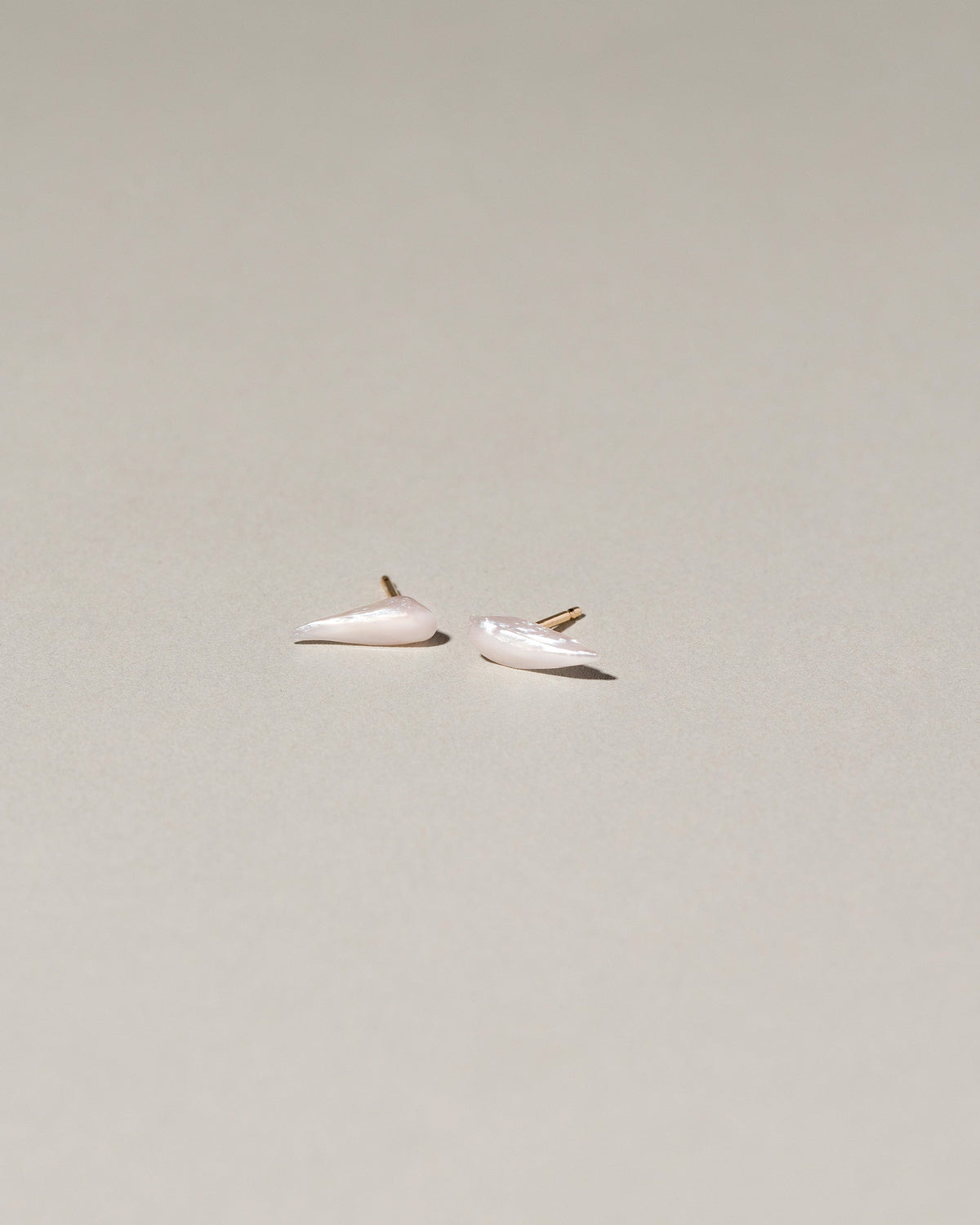  Wing Pearl Stud Earrings on light color background.