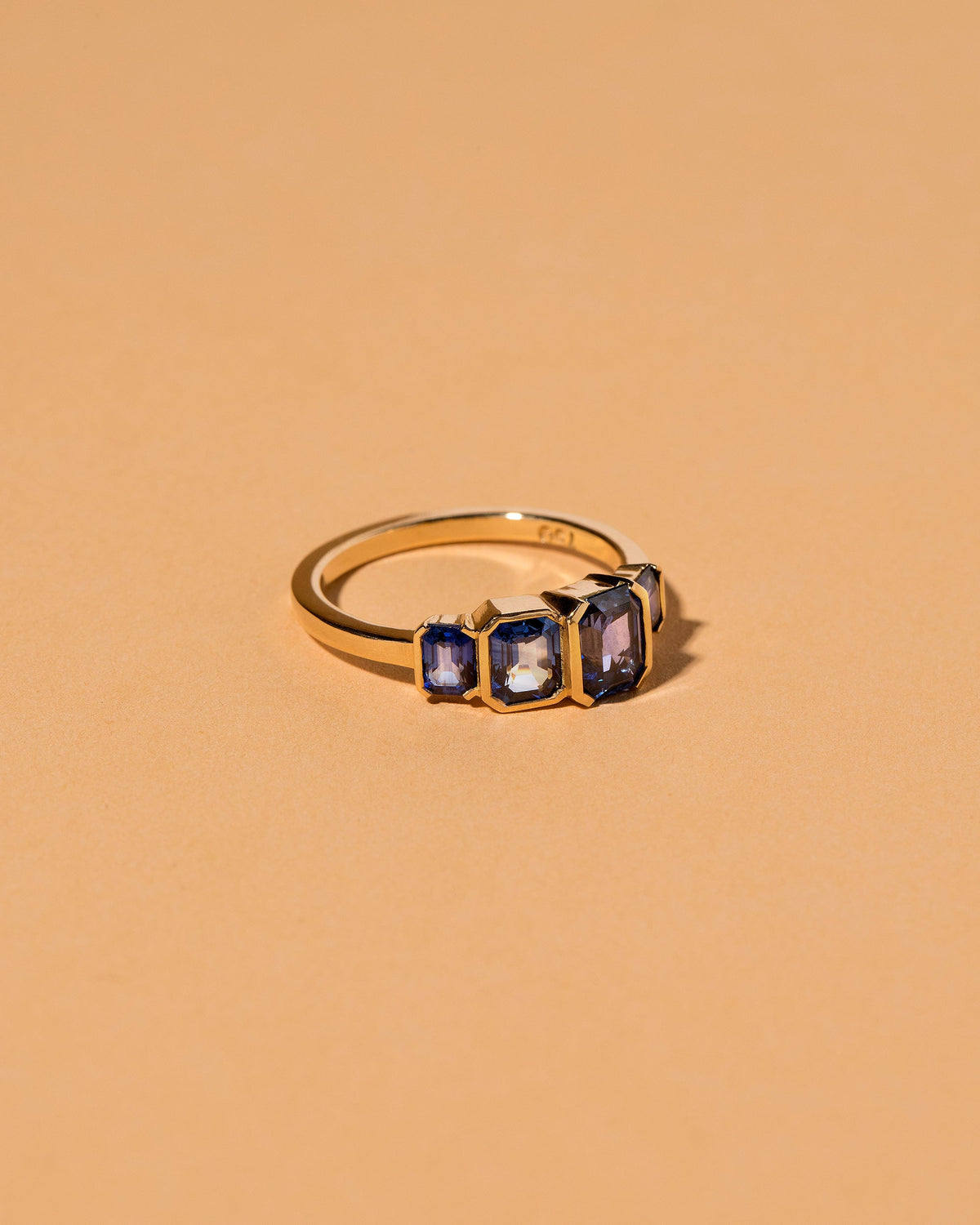 View from the side of the Geometric Sapphire Line Cluster Ring on light color background.