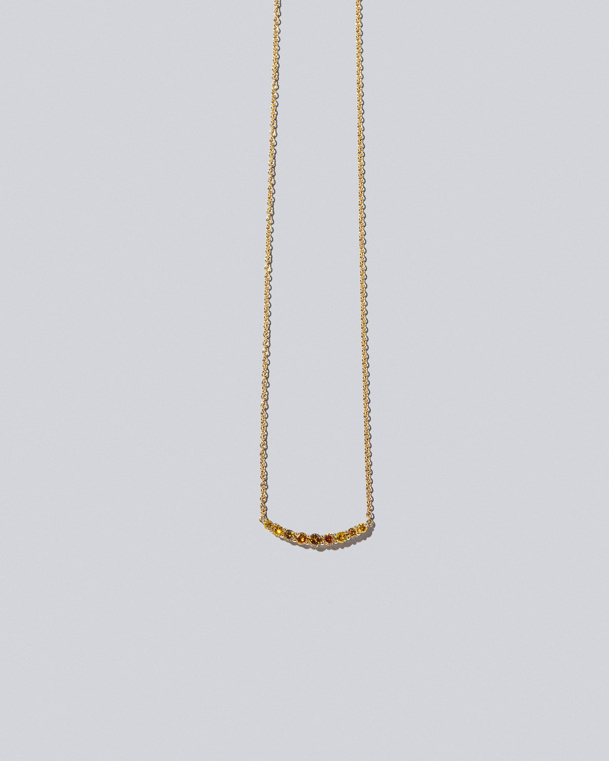 Yellow Diamond Crescent Necklace on light color background.