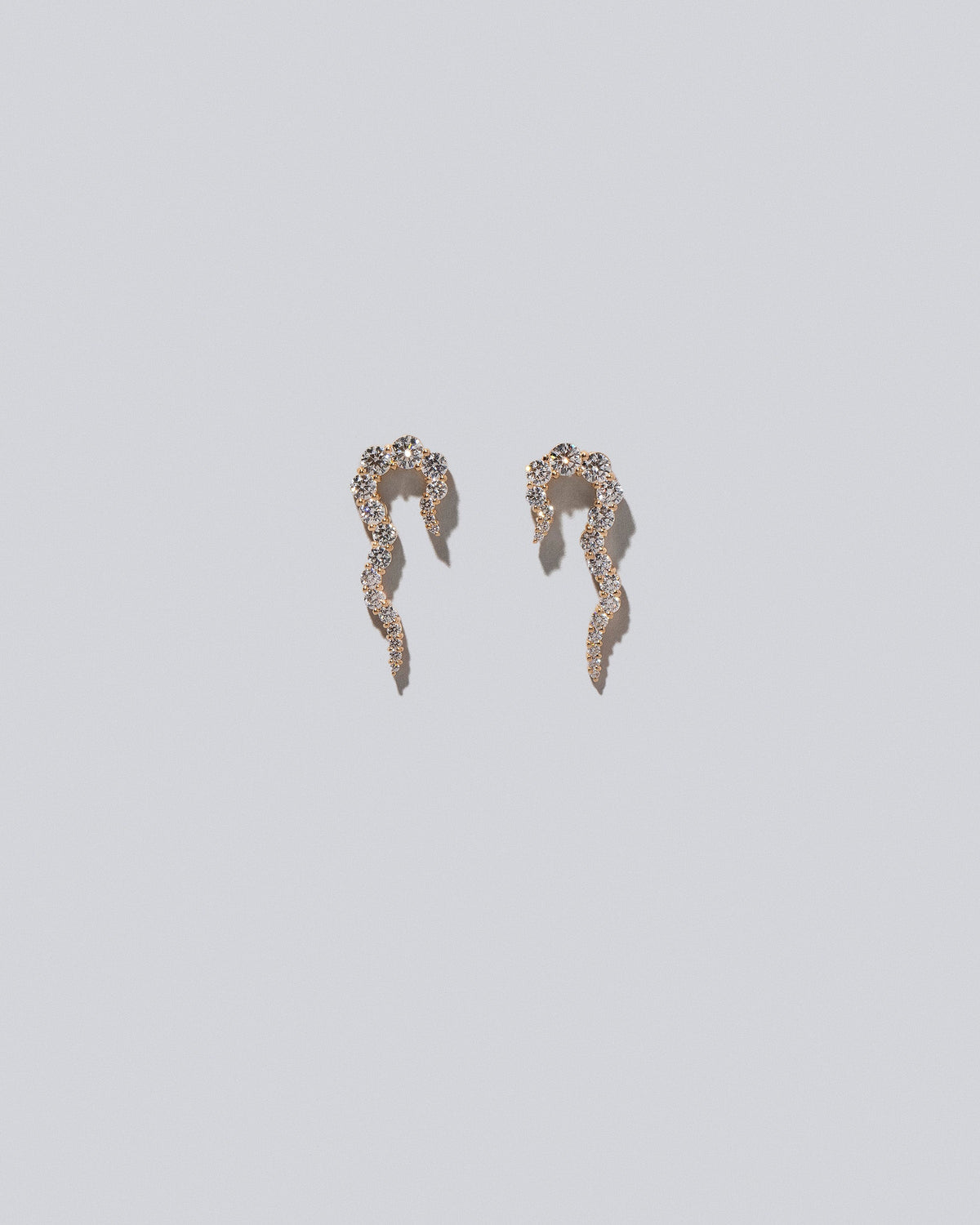 Gold White Diamond Right Tidal Wave Earring Single and Gold White Diamond Left Tidal Wave Earring Single on light color background.